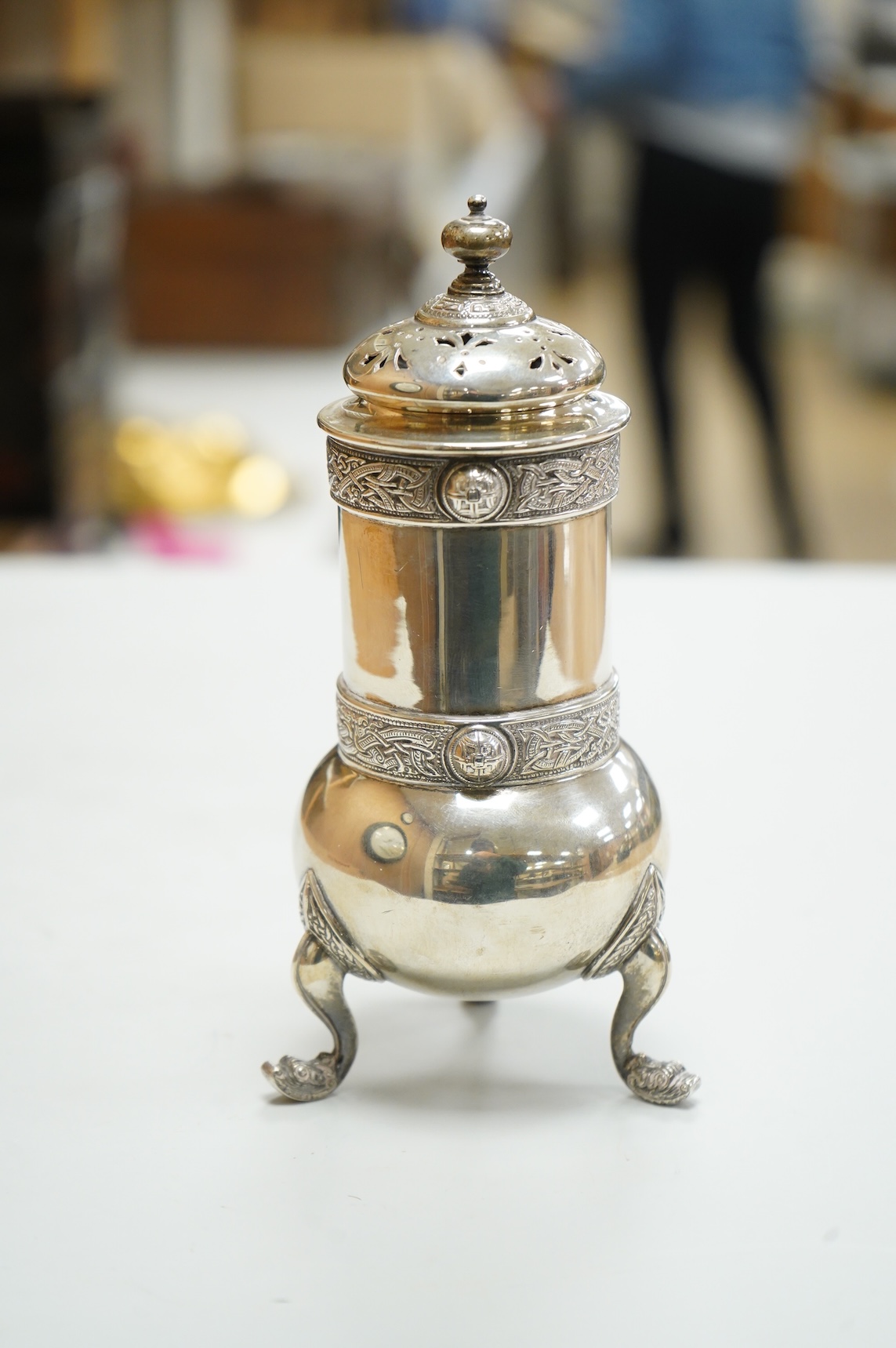 A George V Irish silver sugar caster, by West & Son, Dublin, 1914, decorated with Celtic bands, height 16.7cm, 9.9oz.